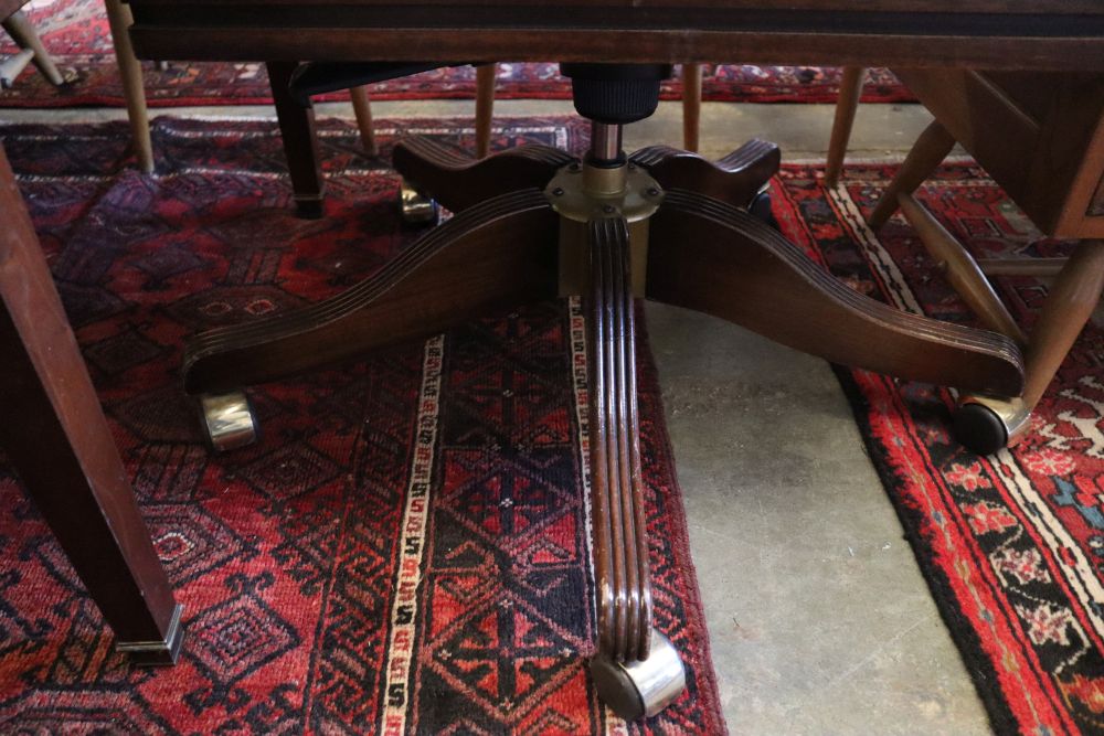 A Reprodux mahogany and tan leather swivel desk chair